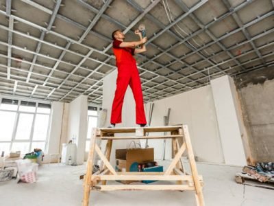 Man in builder uniform installing suspended ceiling