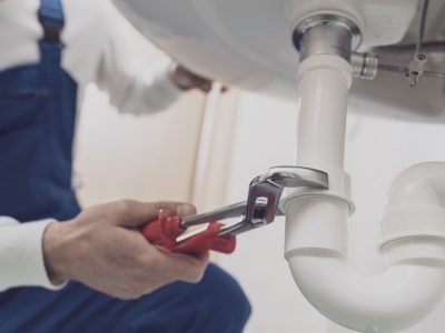 Professional plumber installing or fixing a sink at home